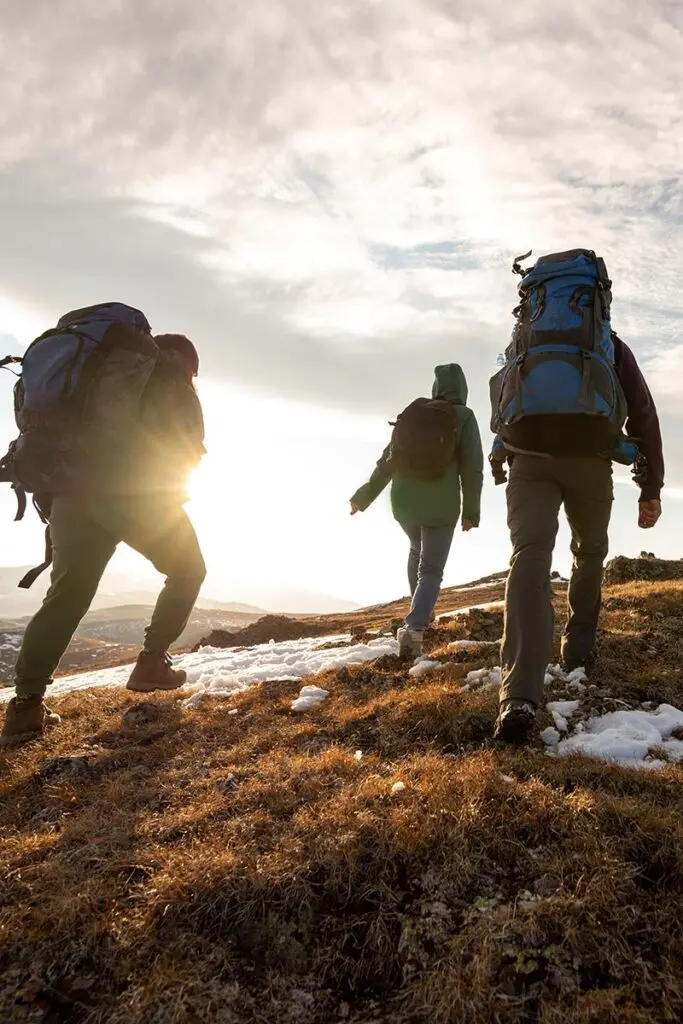 Small group of hikers going up a snowy hill